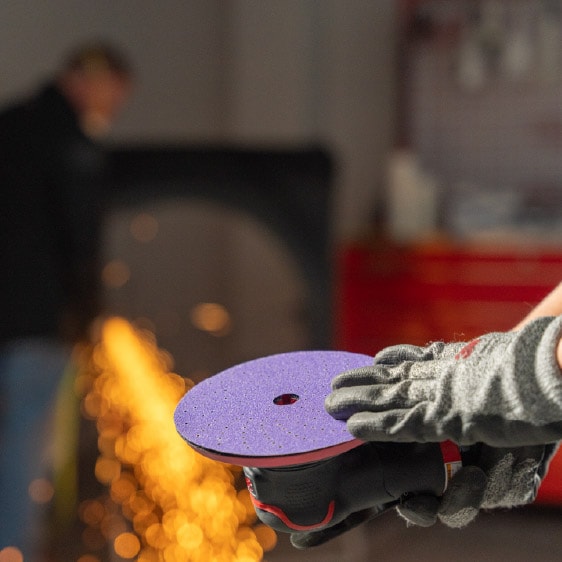 Profissional usando equipamento de proteção enquanto aplica tinta com a pistola de pulverização Performance Spray Gun 3M em um ambiente controlado.