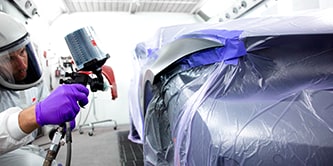 Técnico pintando um carro.
