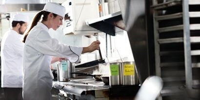 Chefes trabalhando em uma cozinha limpa.
