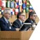Five men sitting in a row on a panel being asked and answering questions.