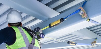 Worker among beams connected by pair of self-retracting lanyards
