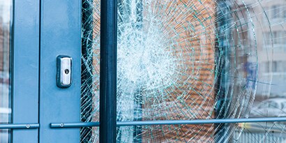 The broken glass of a door is held in place with window film.
