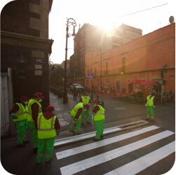 Crew applying white liquid pavement for a crosswalk.
