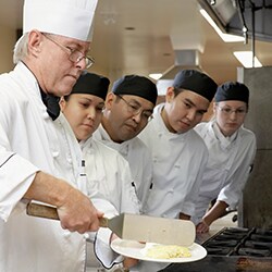 Chef treinando funcionários juniores da cozinha.