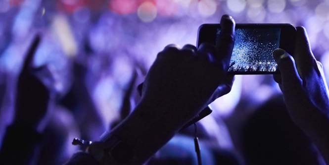 Telefone realizando uma transmissão de vídeo em um show.
