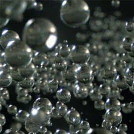 Imagem de várias Microesferas de Vidro 3M™ em um fundo preto.