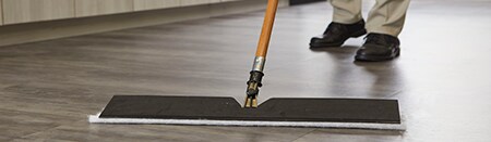 Close-up de um mop em pisos laminados de madeira.
