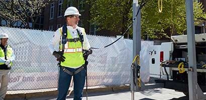 Worker wearing fall protection PPE standing on demonstration platform
