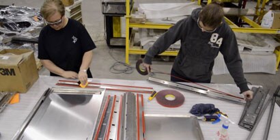 Image of two people applying VHB tape
