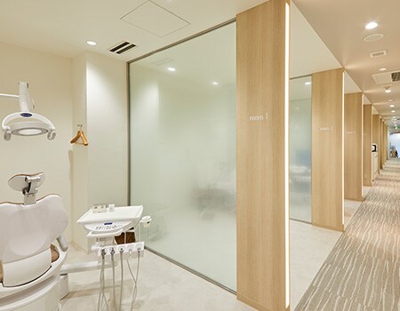 Imagem de consultório de dentista com janelas de vidro e paredes de madeira clara renovadas com acabamentos para vidro e de superfícies 3M.
