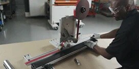 Um homem com equipamento de segurança usa o 3M™ Straight Line Laminator.
