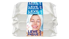 Três pacotes brancos empilhados de lenços ou similares, envoltos por uma faixa azul com o texto ‘Leve 3 Pague 2’. A imagem na faixa tem o rosto borrado.

