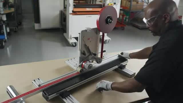 Imagem de alguém empurrando um poste através do laminador de linha reta 3M™.
