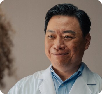 Closeup of a Doctor in a white coat smiling.
