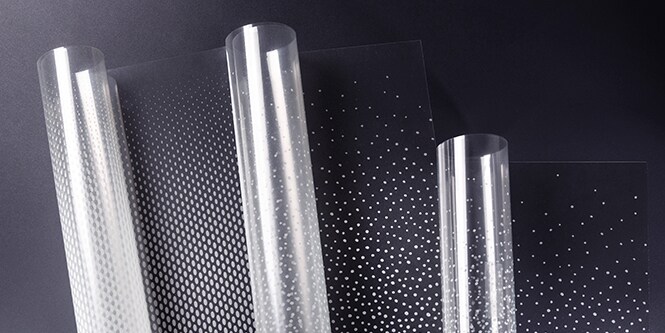Três rolos do acabamento para vidro 3M FASARA com padrões de gradação de pontos sendo desenrolados.
