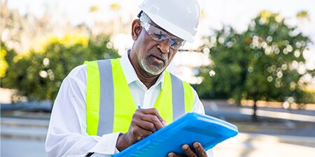A road safety expert writing on a clipboard.
