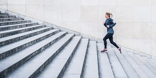 Woman jogging up a flight of stairs
