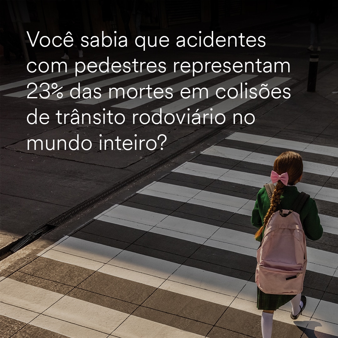A girl with a backpack starting to cross a white stripe painted crosswalk.