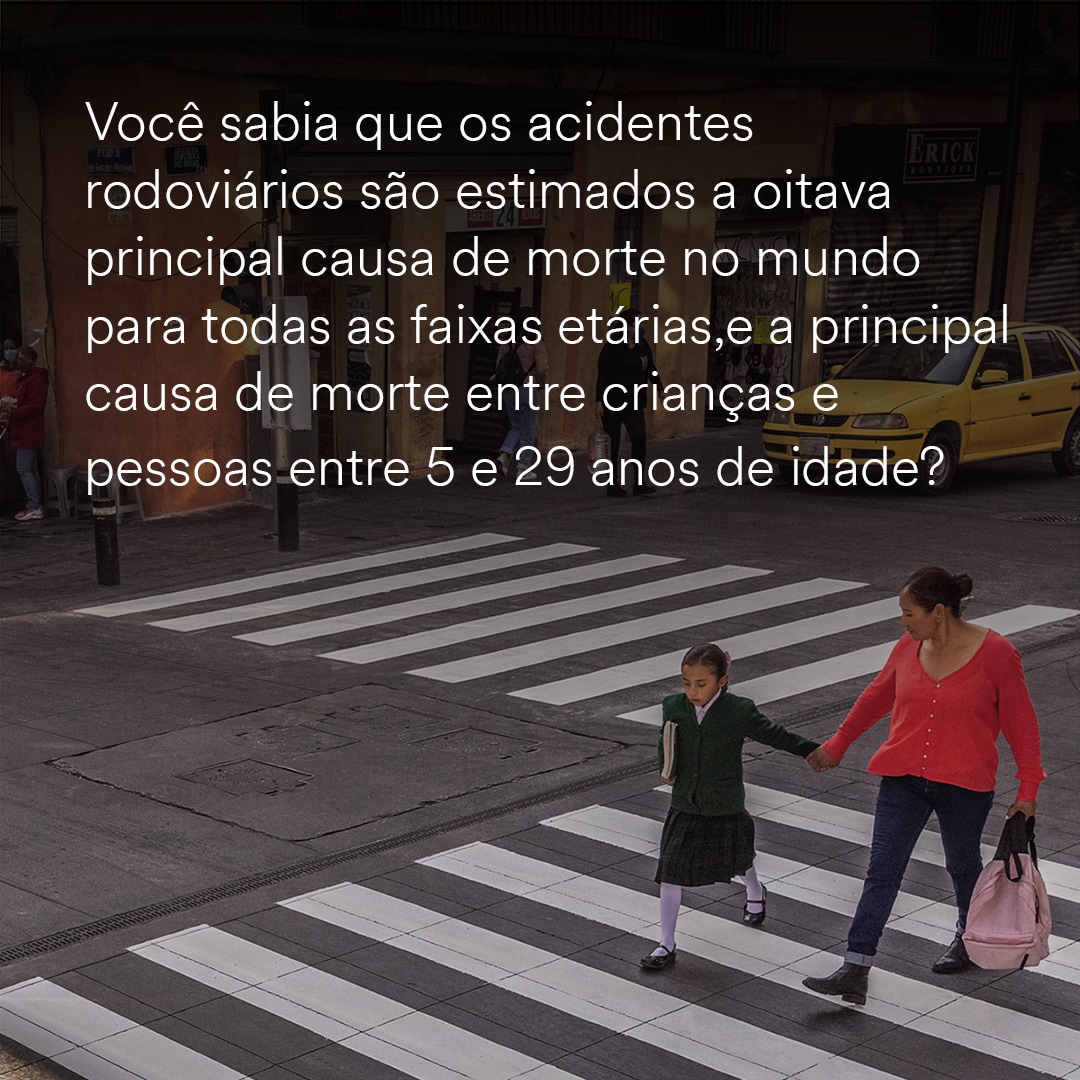 Mother and daughter holding hands crossing in a white stripe painted crosswalk.