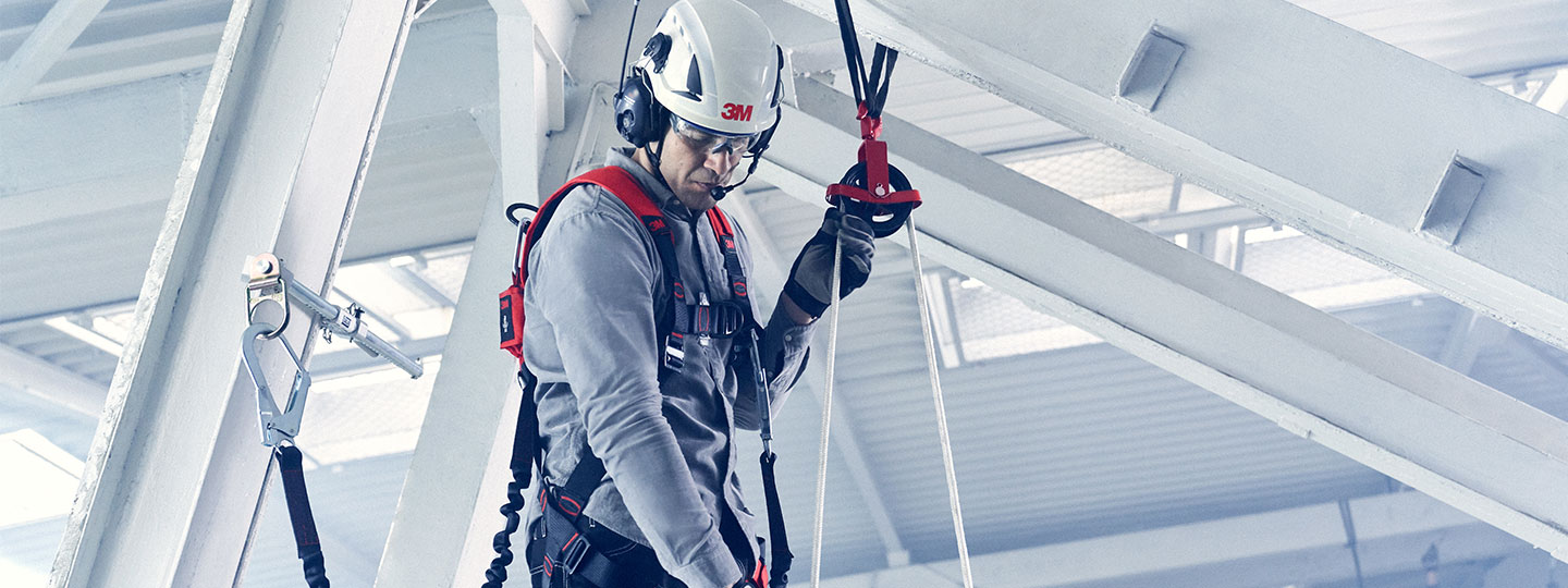 Imagem de homem trabalhando em altura sinalizando equipamentos com círculos vermelhos.
