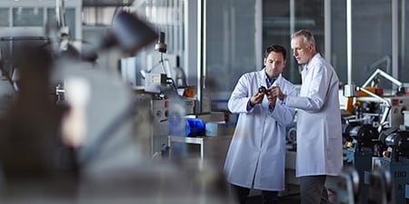 Dois engenheiros em uma oficina de carros.
