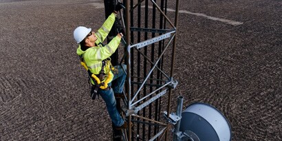 Worker climbing ladder secured by LadSaf system
