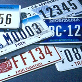 stack of license plates from Montana, Polk, firefighter, blue, white, and red