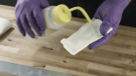 Video still showing a person wetting a cloth with an isopropyl
