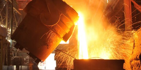 metal derretido sendo derramado em planta de processamento de metal
