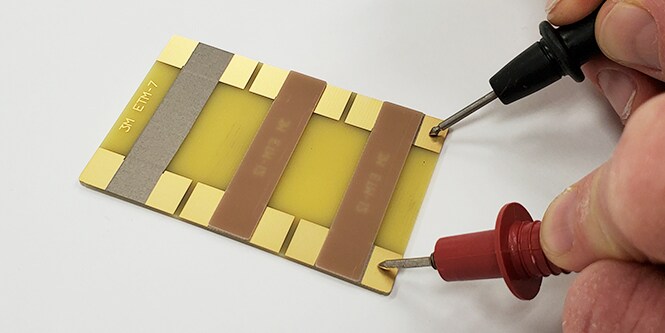 Alguém testando a resistência elétrica em vários materiais.
