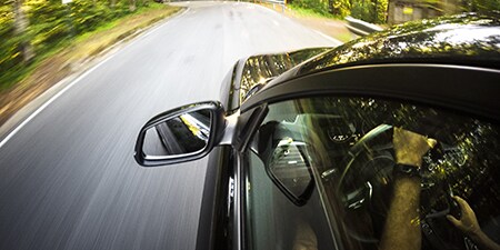 Imagem de um carro em movimento em uma estrada.
