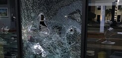 Estilhaços de janela quebrada sendo mantidos juntos com a película protetora para janelas.