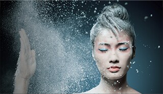 Portrait of a young adult woman with makeup explosively moving around her face, illustrating the dynamic nature of design.