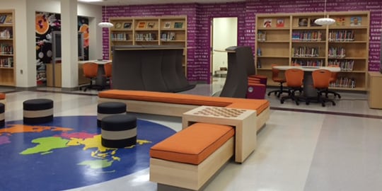 Uma biblioteca com um grande gráfico de vinil no chão do globo terrestre.
