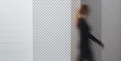 3M™ Glass Finishes blur the view of a woman walking past a window while shades of light still show. 