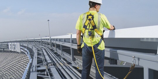 Worker on stadium roof secured to permanent lifeline
