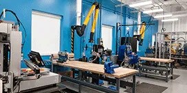 Centro de Processos de Colagem da 3M com duas mesas com máquinas e equipamentos.
