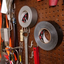Image of a pegboard with tools, including two rolls of 3M duct tape