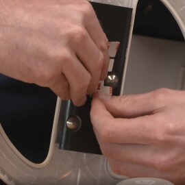 A person placing die-cut tape in an application