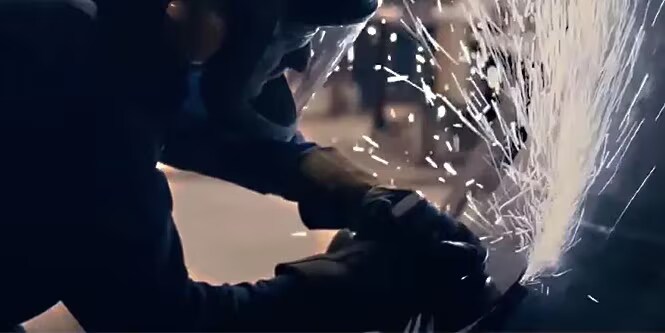 Trabalhador metalúrgico usando produto abrasivo para soldagem e fabricação de metal.
