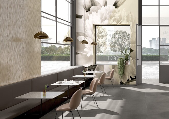 Interior de uma cafeteria decorado com tons neutros e uma estampa floral impressa em filme gráfico cobrindo as paredes.