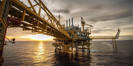 Imagem de uma plataforma de petróleo no meio do oceano.
