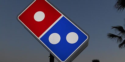 Sinal luminoso da Domino's Pizza envolvido em filme translúcido da 3M imprimível e colorido
