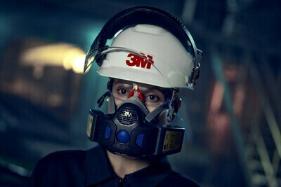 Trabalhador utilizando respirador, capacete e óculos de proteção 3M.
