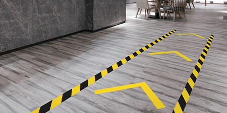 Visão aproximada das fitas de demarcação de solo 3M aplicadas em um padrão de seta.
