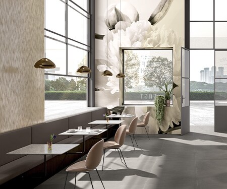 Interior de uma cafeteria decorado com tons neutros e uma estampa floral impressa em filme gráfico cobrindo as paredes.
