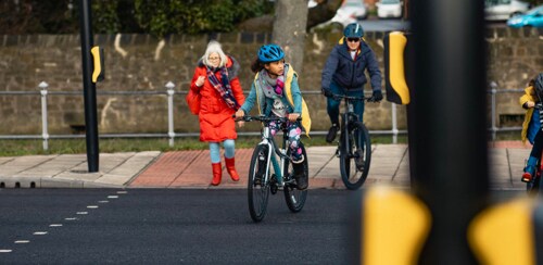 Children on bikes crossing in a crosswalk.
