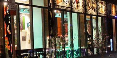 Uma fachada à noite com um interior iluminado e vitrines com gráficos de janela.
