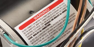 A warning label attached to a motor in an appliance
