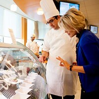 Chef e gerente examinam a vitrine dentro de um restaurante.